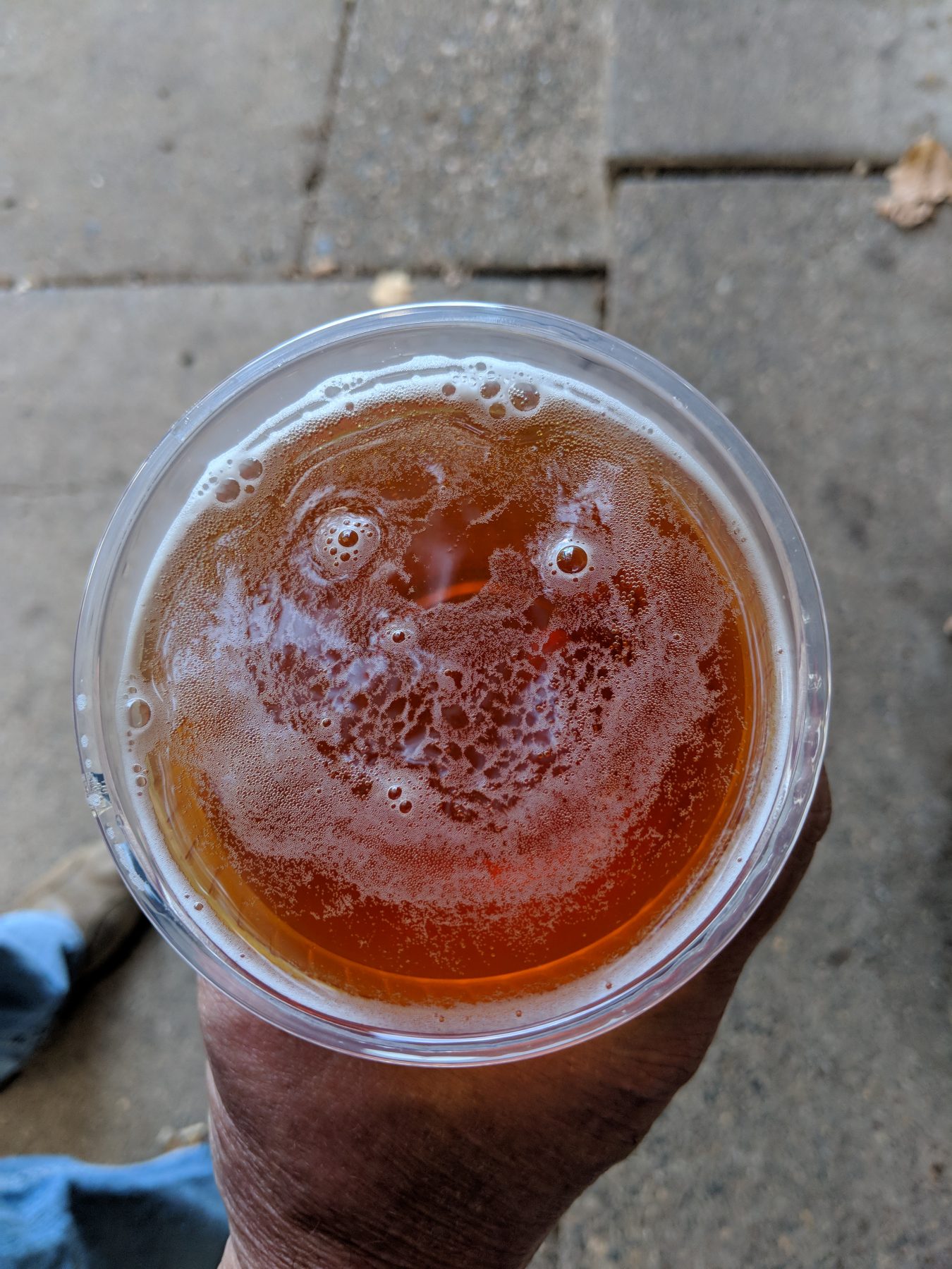 Top of beer cup with smiley face in foam