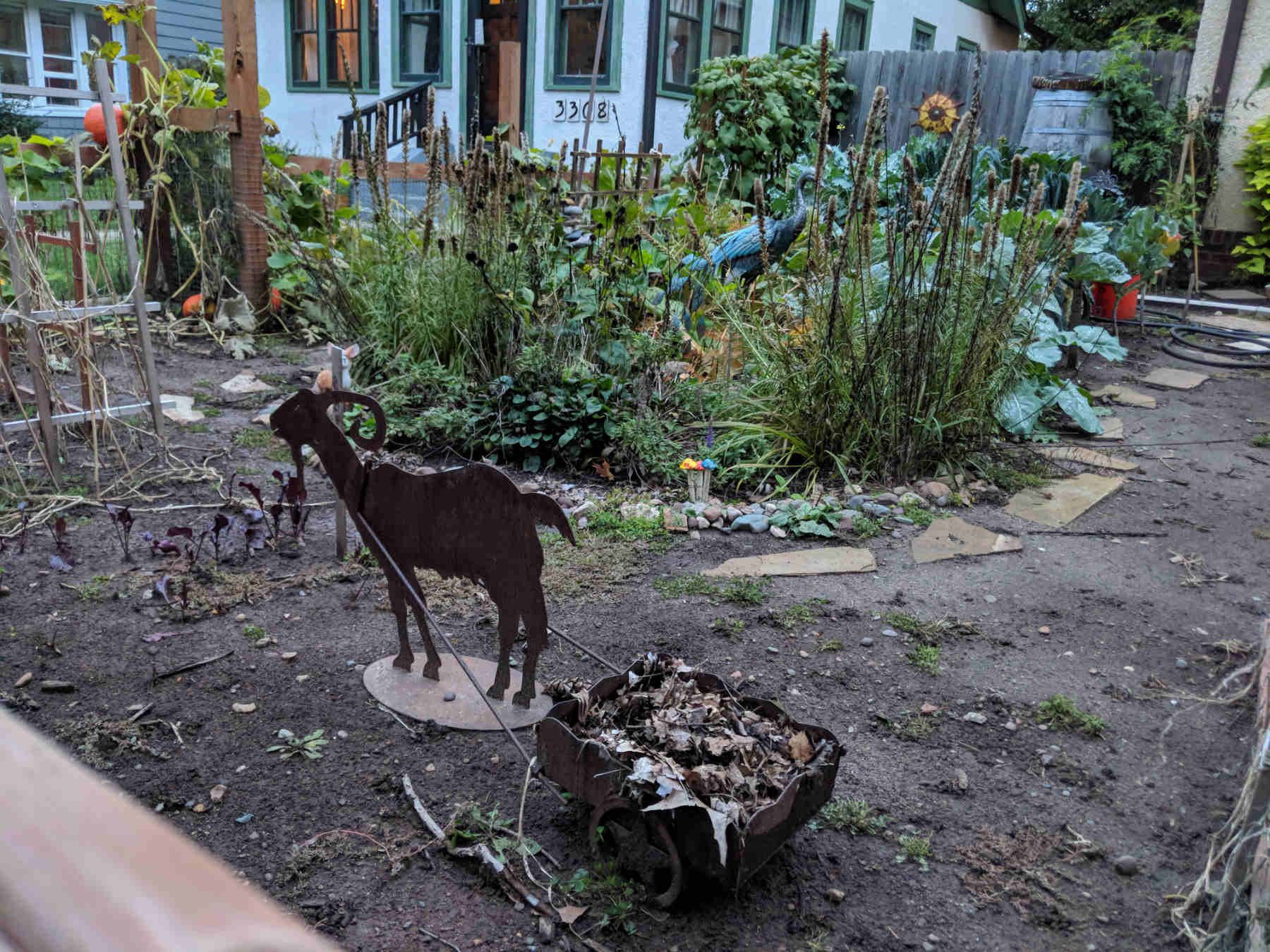 yard art sculpture of goat pulling little wagon