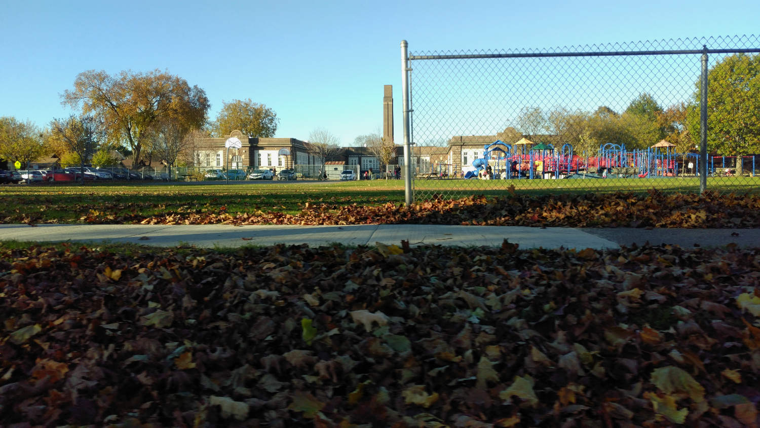 park landscape with school and playground in background