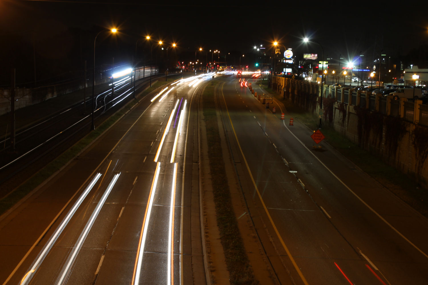 Streaming car lights on highway at night seen from overpass