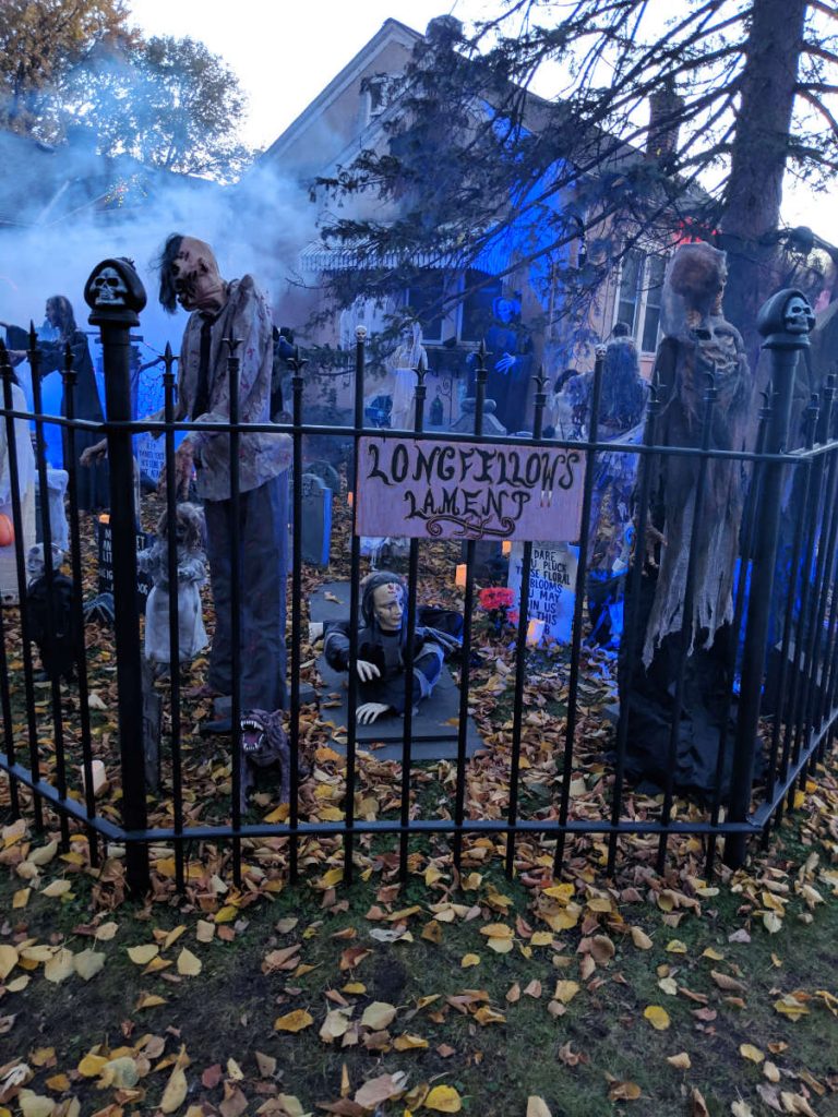 Longfellow's Lament sign on fence in front of spooky yard