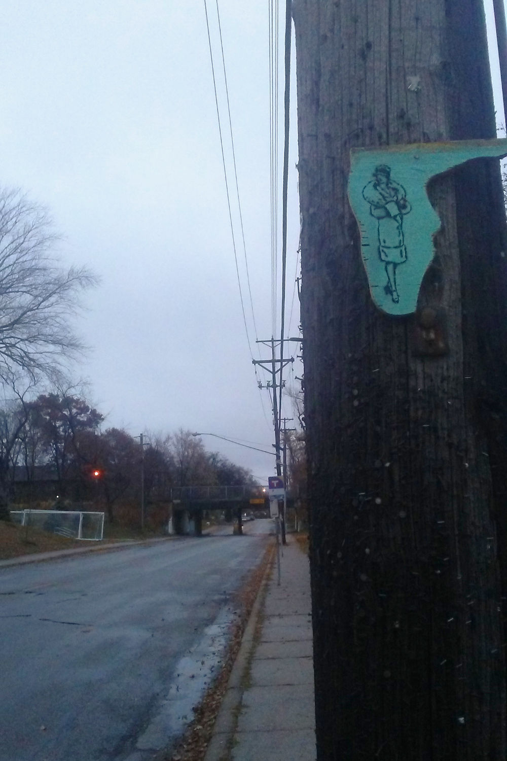 Sketch of woman in winterwear on metal on telephone pole