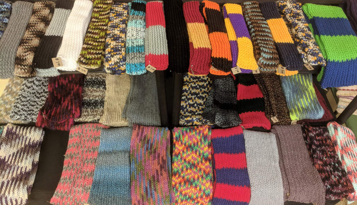 Multi-colored knit scarves lined up in three rows
