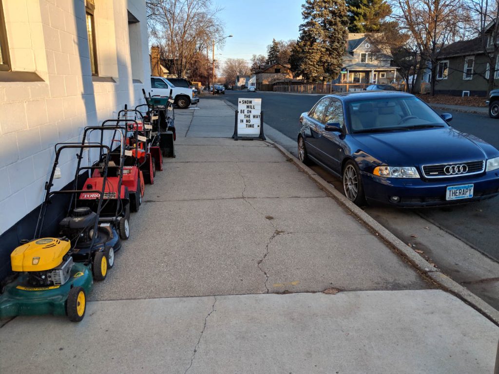 Sidewalk with lawn mowers and snowblowers
