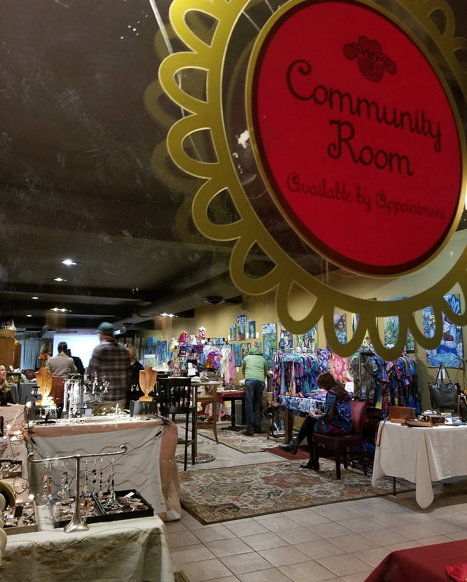 Community Room sign in foreground with craft table exhibits in background
