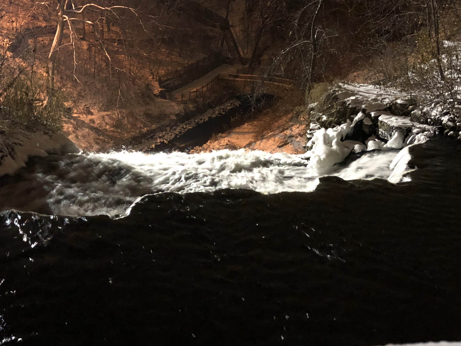 highlighted cascading falls from above at night with dark snowy background