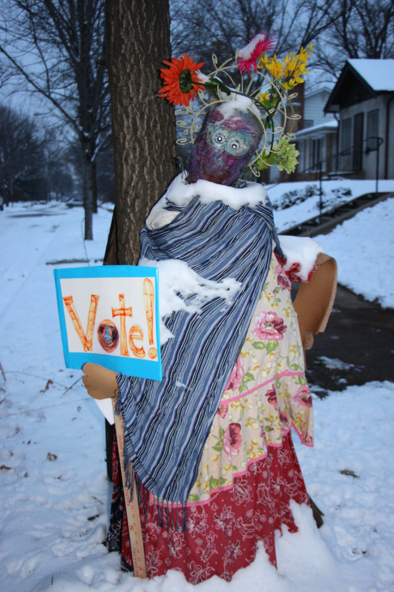 snow woman made up sort of like the Statue of Liberty holding a Vote! sign