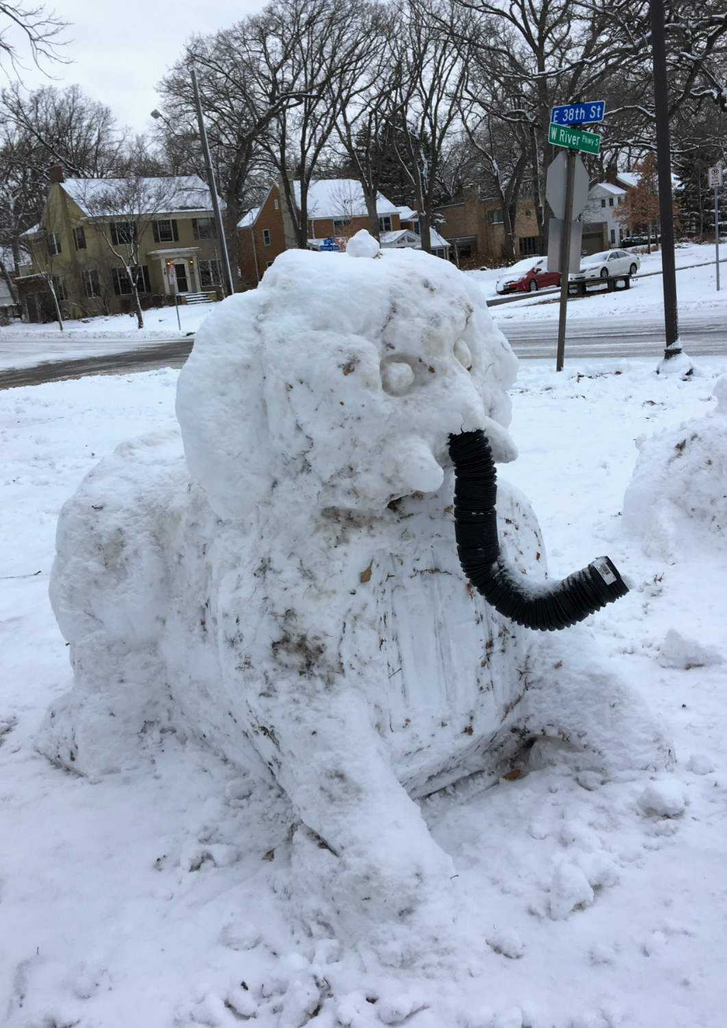 Elephant sculpted from snow with a black flex hose for trunk