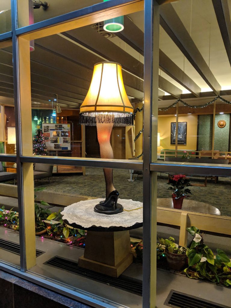 window view of a lamp with a mannequin leg post in a lobby