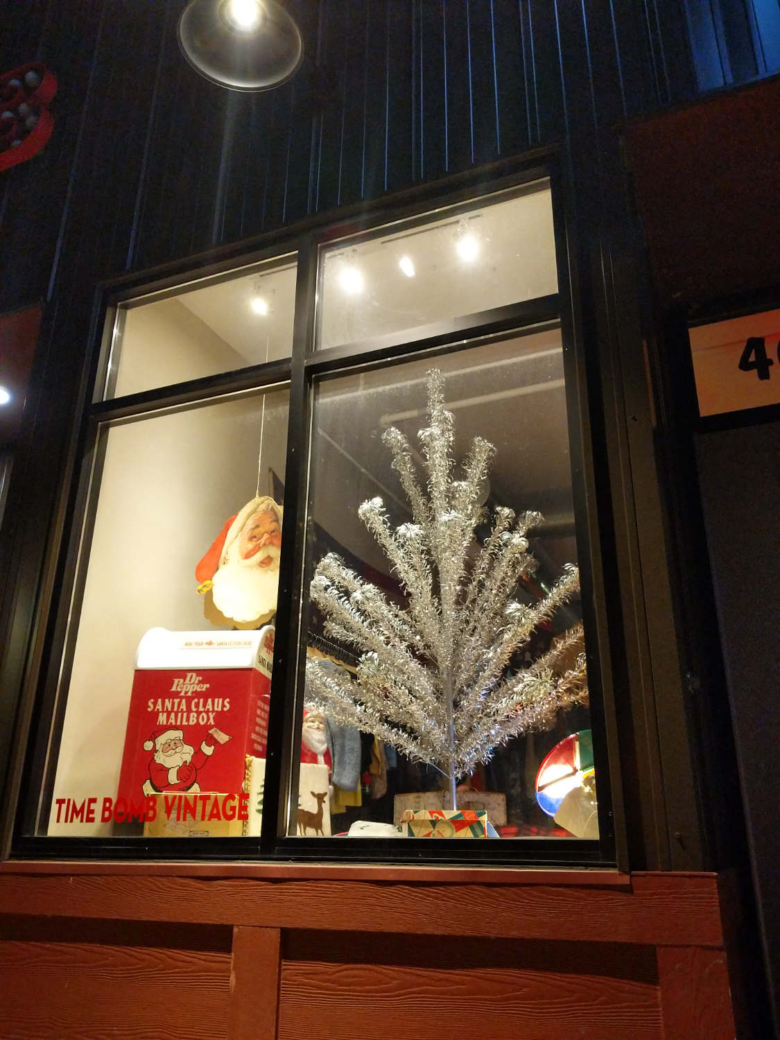 silver artificial christmas tree and santa display in store window