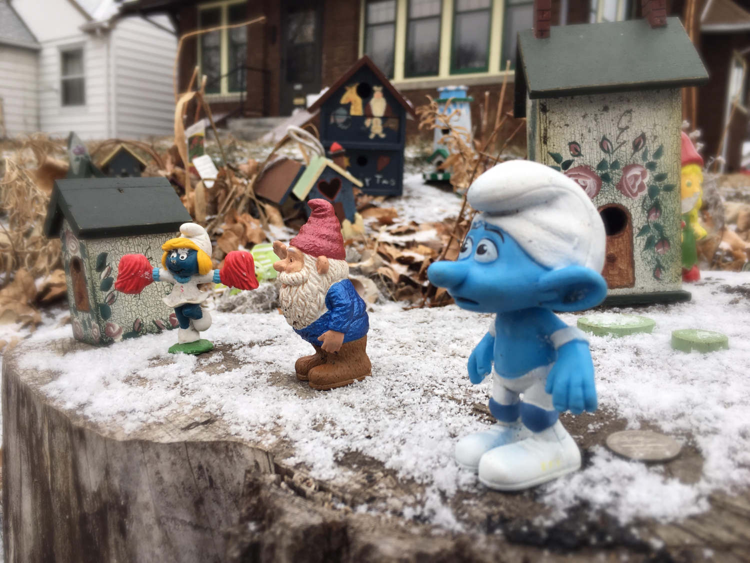smurf and gnome statuettes on frosted wood stump with toy houses