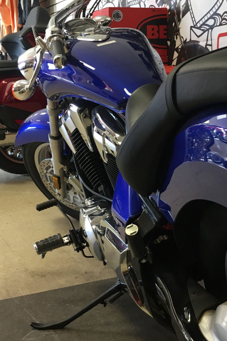 blue and black motorcycle parked inside a showroom