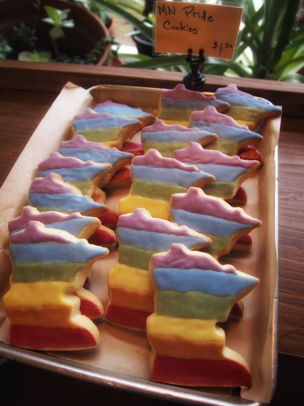 Tray of Minnesota state-shaped rainbow-frosted cookies.
