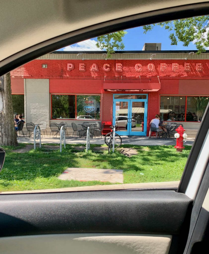 red storefront with peace coffee signage viewed from a car window