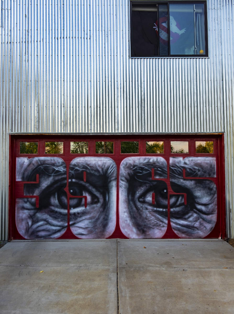 loading door on building with a mural of two eyes in black and white