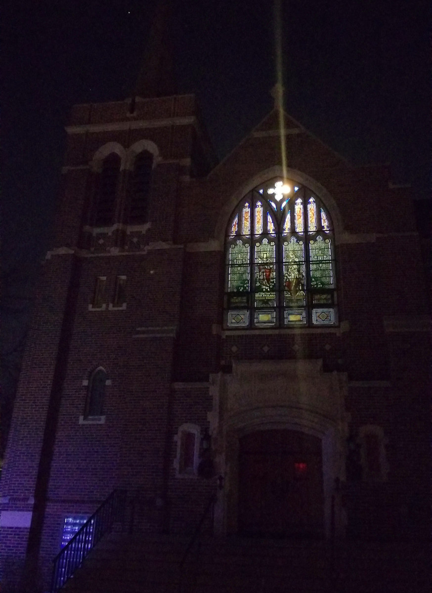stained glass window lit up high on church at night
