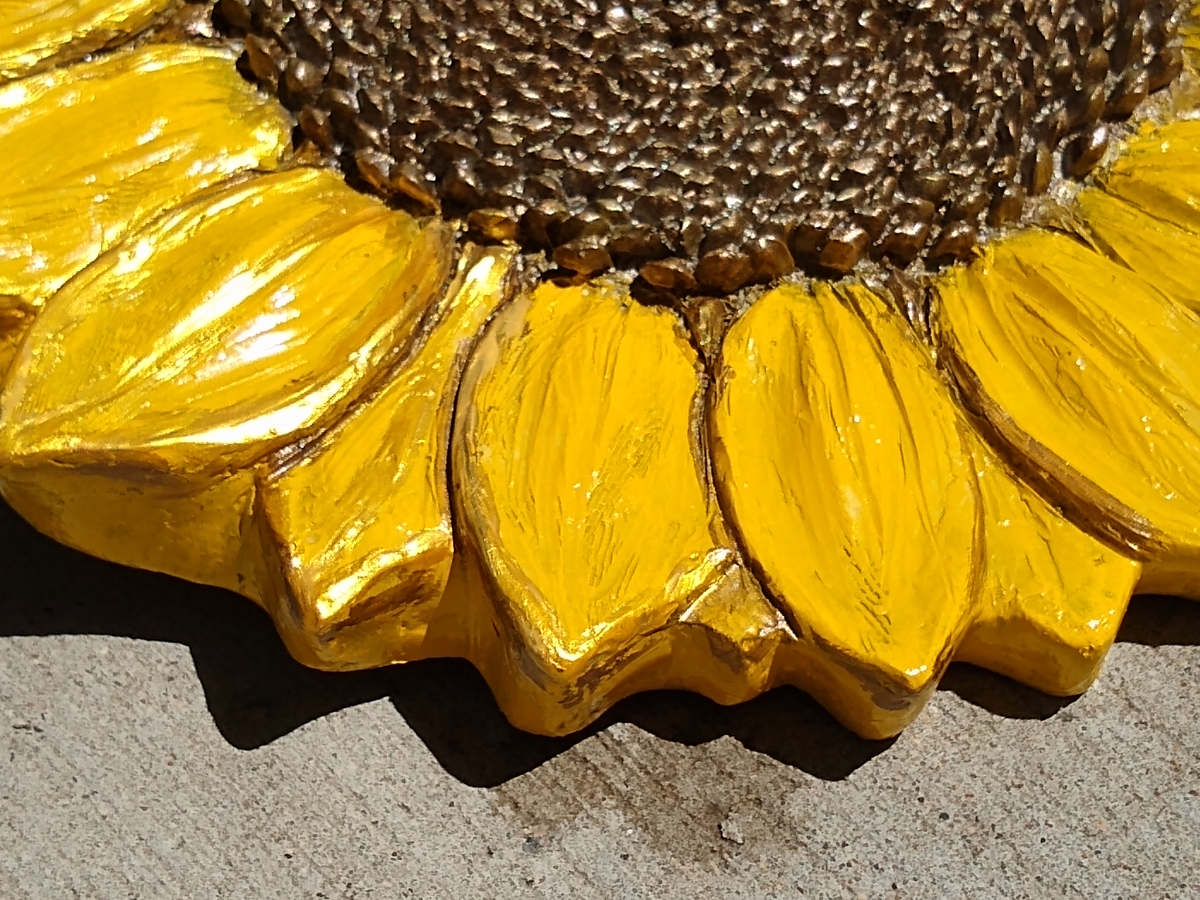 cropped closeup of a bright yellow painted sunflower art casting