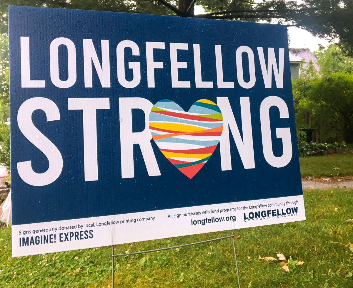 lawn sign reading "LONGFELLOW STRONG" with a multi-colored heart for the letter O in strong