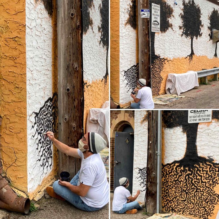 Triptych view of an artist, wearing a mask, works on painting a mural of tree silhouettes with roots on side of building